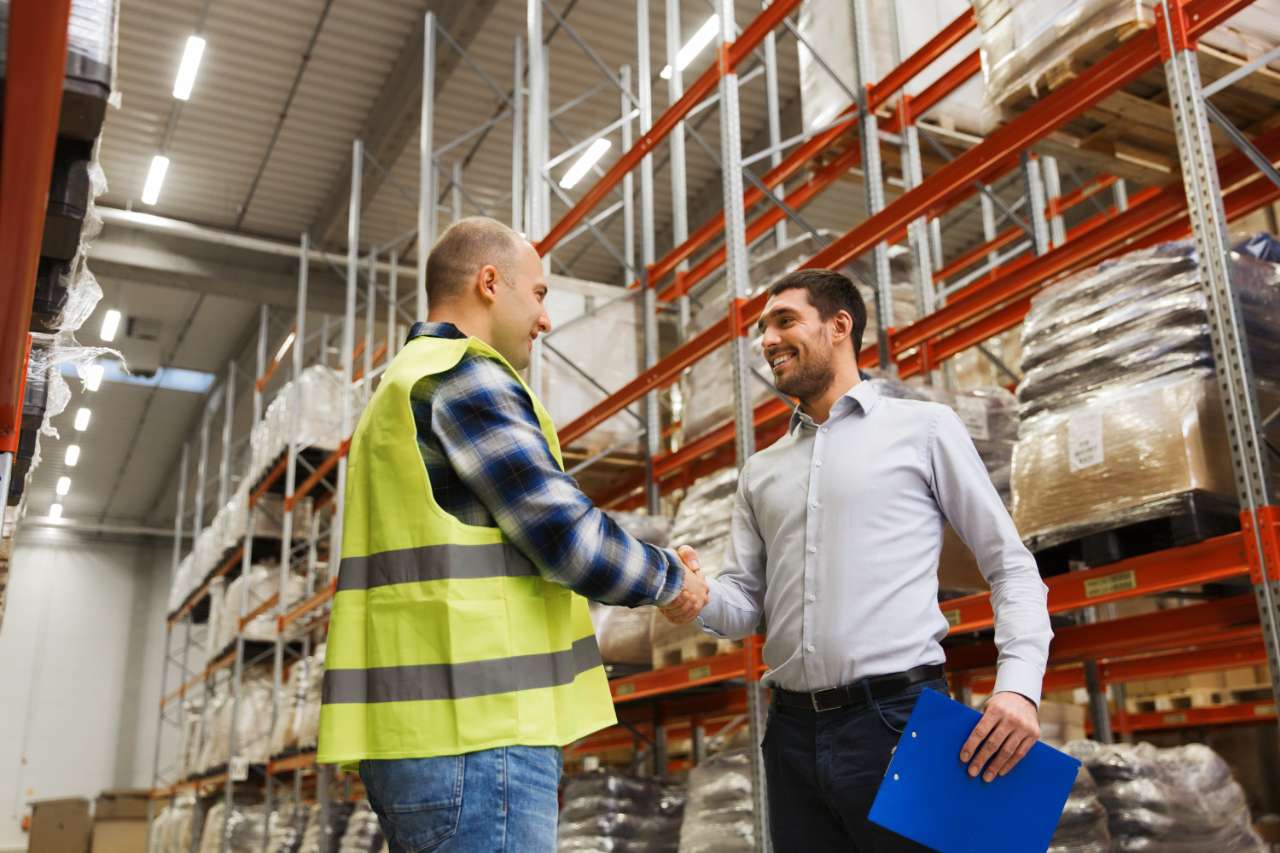 two people shaking hands in a warehouse