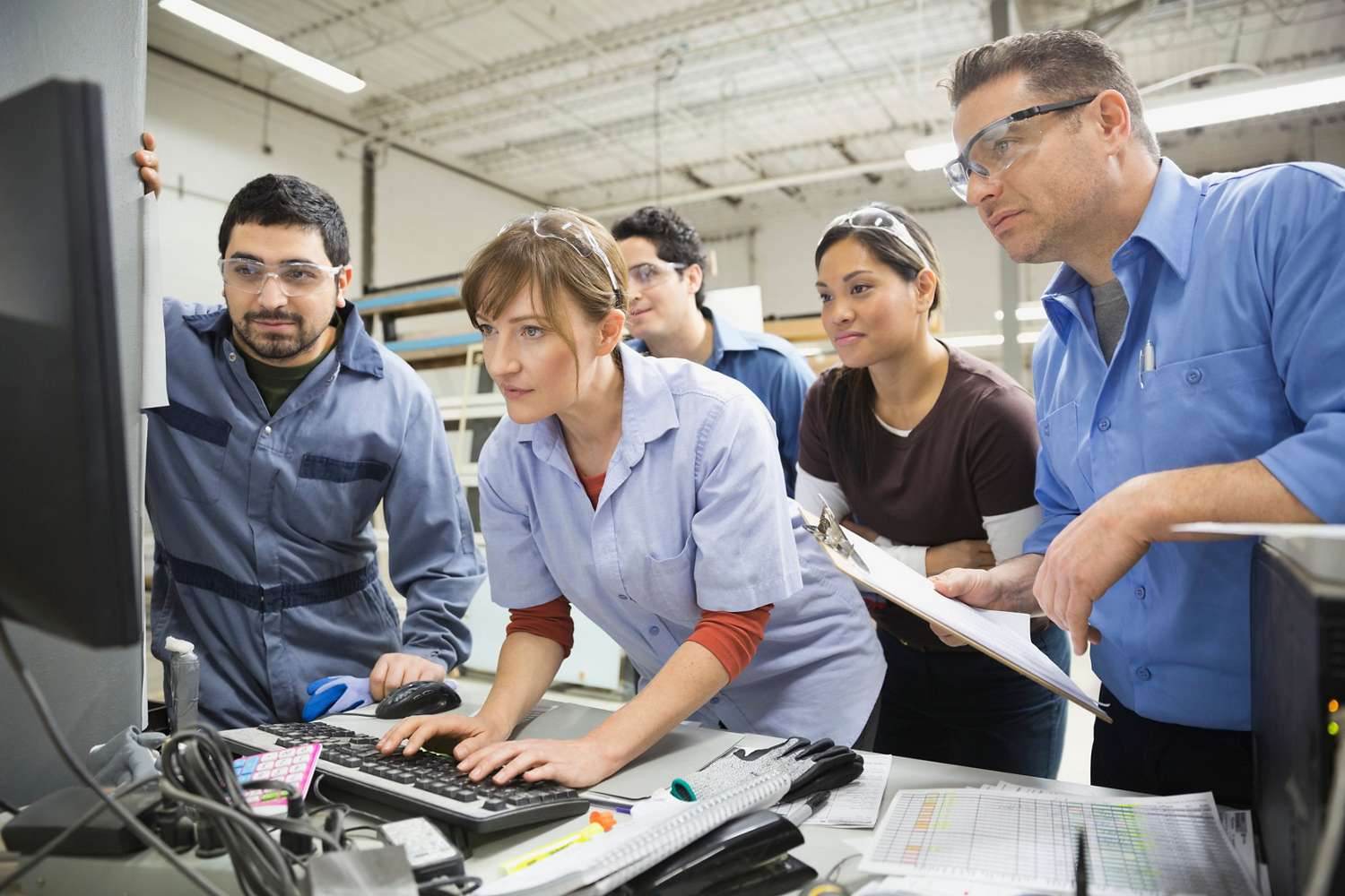 Workers using computer in warehouse